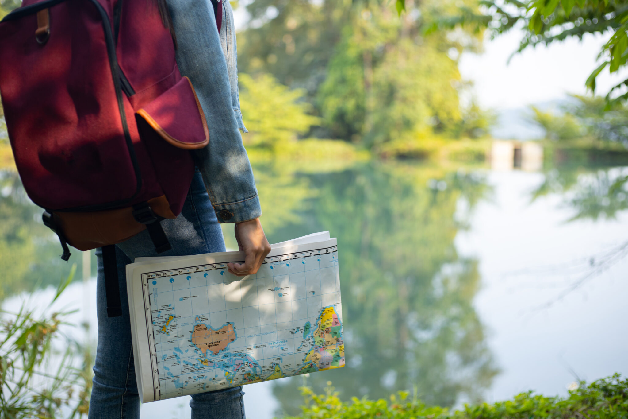 Dievča cestovateľka hľadá správny smer na mape. Objavte dobrodružstvo a zvedavosť pri cestovaní s mladou cestovateľkou, ktorá sa snaží nájsť správnu cestu pre ekologické prostredie.